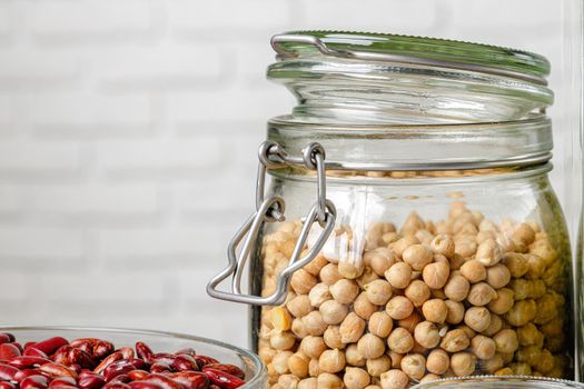 Raw cereals or beans in glass jars close up. Vegan and vegetarian food.