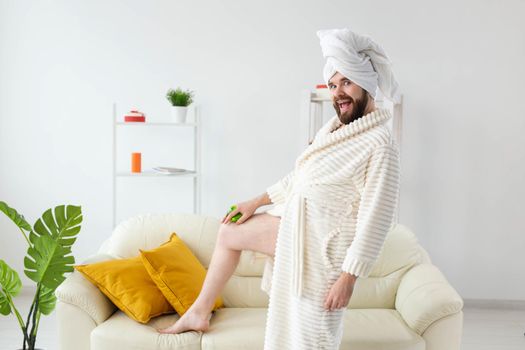 Funny bearded man wear turban towel makes himself a massage with massage brush. Male skin care and spa concept.