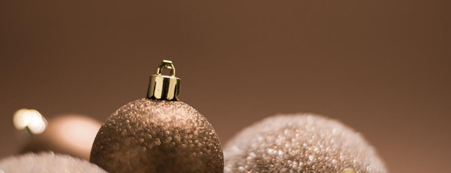 Christmas holiday and festive decoration concept. Golden baubles on beige background