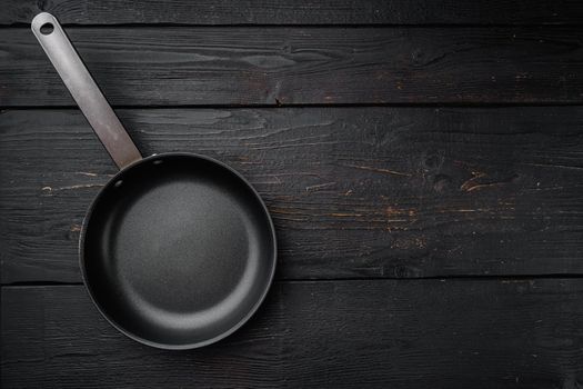Cast iron frying pan with copy space for text or food with copy space for text or food, top view flat lay , on black wooden table background