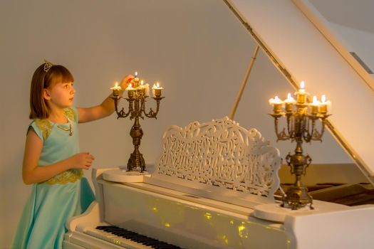 Little girl lights candles on Christmas night.