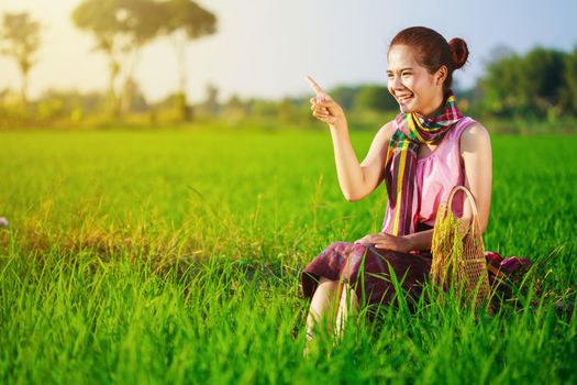 happy farmer woman sitting in rice filed, Thailand