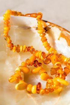 Solar beads of fiery amber on onyx marble background. Natural stone backdrop