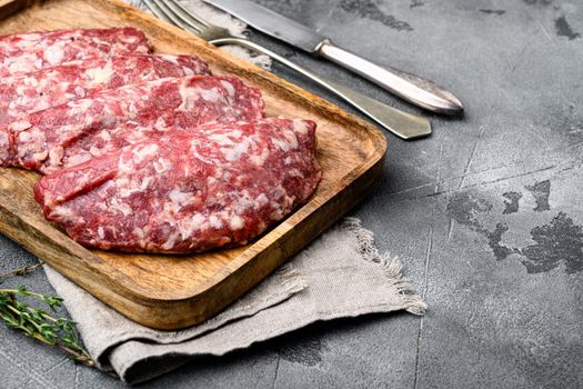 Ground raw meat patties. Meat patty, on gray stone table background, with copy space for text