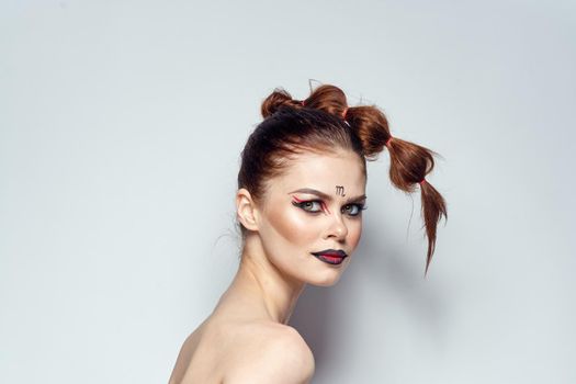 attractive woman posing scorpio sign on forehead cosmetics light background