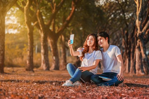 couple using mobile phone taking a selfie in the park