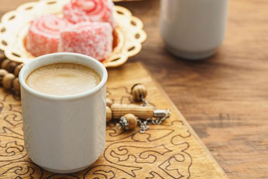 Coffee cup with oriental sweets on wooden table