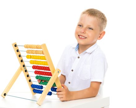 Little boy uses abacus to solve mathematical problems.
