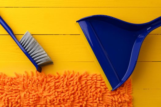 Household cleaning brush on yellow wooden background