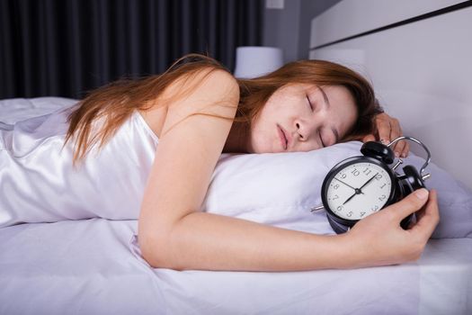 woman sleeping on bed with clock show 6 O'clock 