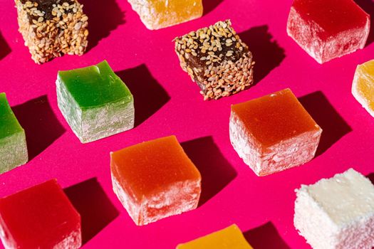 Turkish delight square pieces on a bright pink background