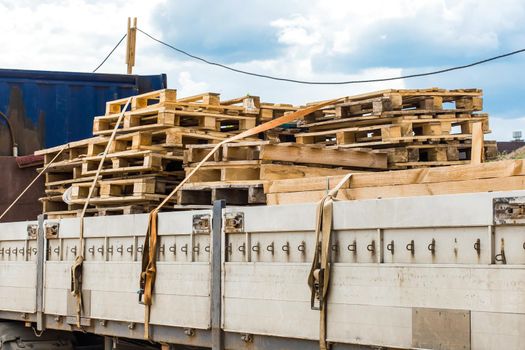 Truck at the construction site transporting wooden pallets, industrial freight or timber cargo