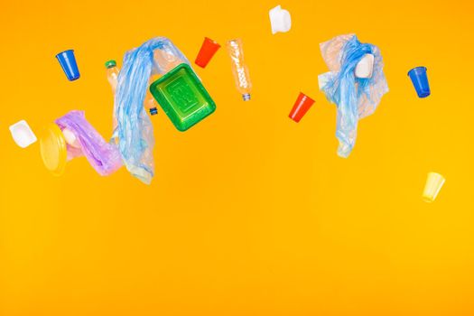 Problem of trash, plastic recycling, pollution and environmental concept - plastic garbage on yellow background with copy space