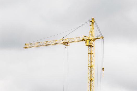 Tower construction building yellow industrial crane against the grey sky