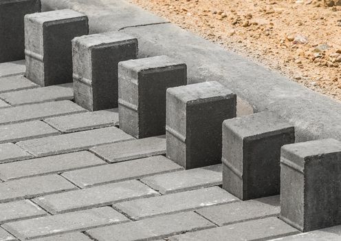 Laying floor tile sidewalk urban road or repairing paving stone slabs at a construction site