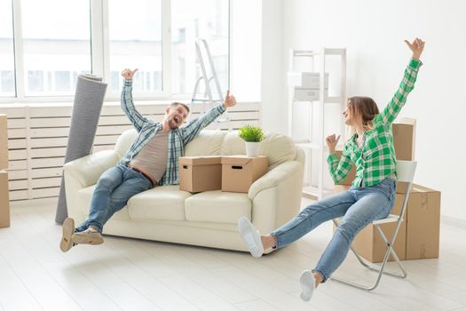 Positive smiling young girl sitting against her laughing in a new living room while moving to a new home. The concept of joy from the possibility of finding new housing.