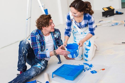 Renovation, repair and people concept - Close up portrait of couple stained with paint over white background