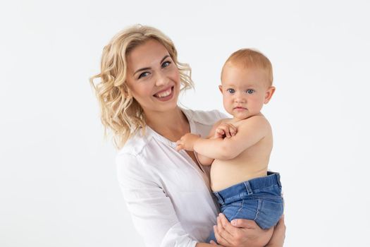 Single parent, motherhood and babyhood concept - Mother holding sweet baby girl on white background