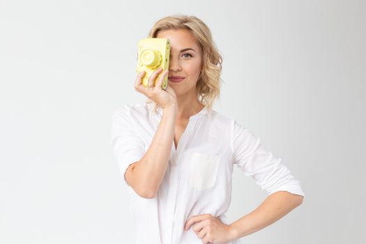 Photographer, hobby and leisure concept - Young blond woman with retro camera on white background with copy space