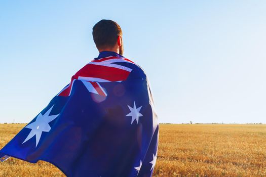 Man with a flag of Australia standing in field