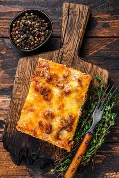 Italian Lasagna with bolognese sauce and mince beef meat. Dark Wooden background. Top view