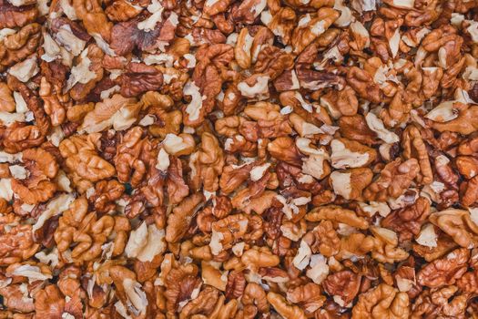 Peeled walnut background, pile of nutshell brown snack texture