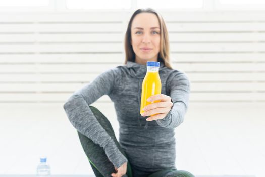 Healthy lifestyle, people and sport concept - Woman with healthy juice drinking for sport and fitness on white background.