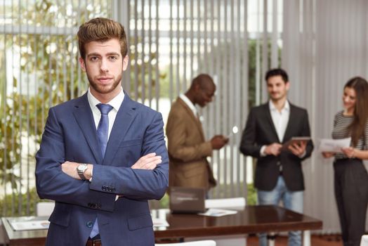 Businessman leader with arms crossed in working environment