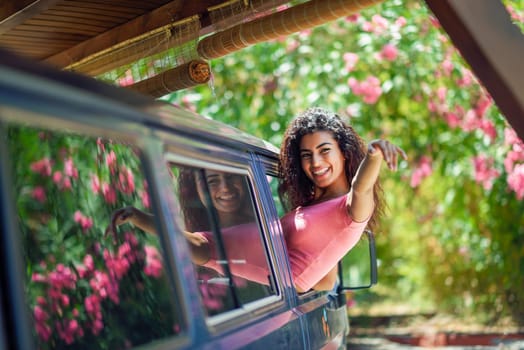 Happy Arab girl peeking out the window of a van