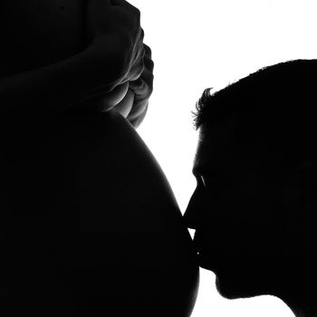 Man kissing his pregnant wife's belly