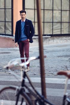 Man wearing british elegant suit in the street near an old bycicle