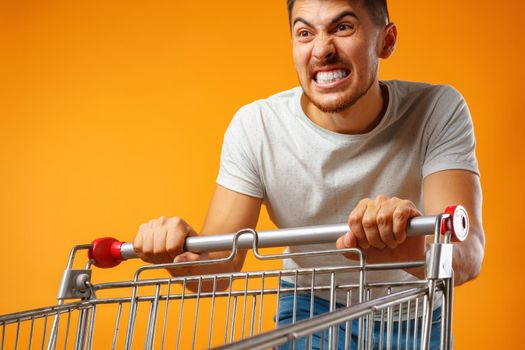 Funny crazy man rushing with shopping trolley to sale