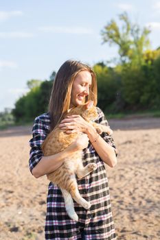 People, tourism and nature concept - Woman holding a cat on nature