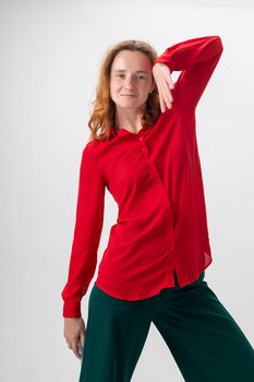 funny caucasian redheaded girl in red shirt fooling around in disco dance pose
