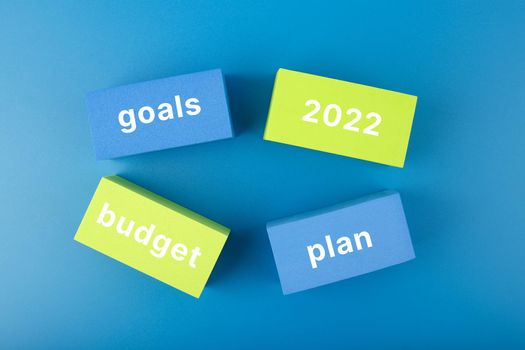 Business plan concept 2022. Text budget, plan, goals 2022 written on colored rectangles on dark blue background