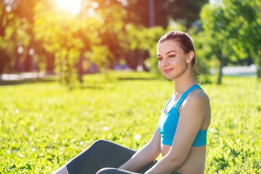 Beautiful smiling girl in activewear relax in park