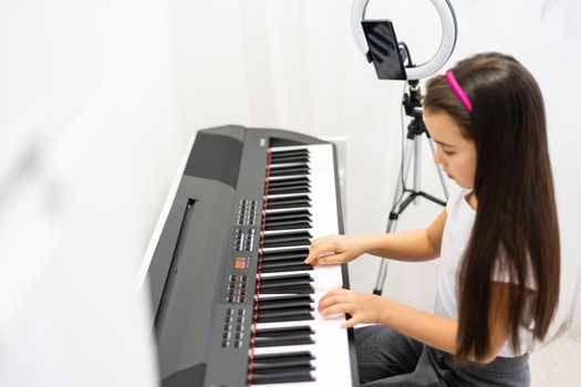 Child Girl Playing Music Keyboard Piano Instrument and shoots a video