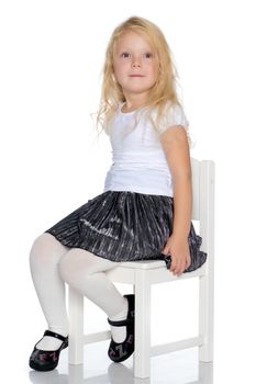 Little girl is sitting on a stool