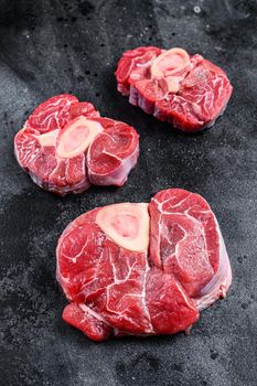 Fresh veal meat osso buco shank steak, italian ossobuco. Black background. Top view