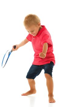 A cute little boy holding a tennis racket in his hands.
