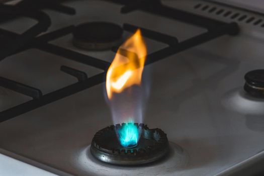 Gas burner with flame from a hole on a gas stove, close-up