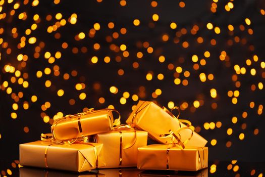 Wrapped Christmas gifts on golden lights bokeh background