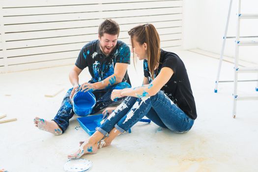 Renovation, redecoration and family concept - Young couple pour paint