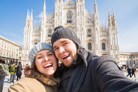 Travel, photographing and people concept - Happy couple taking self portrait in Milano in Duomo square