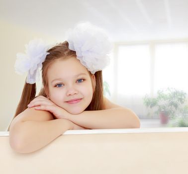 Beautiful little girl with white bows on the head