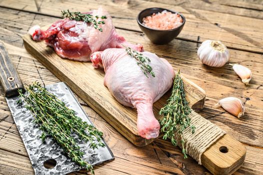 Duck legs on cutting board, Raw meat. Wooden background. Top view