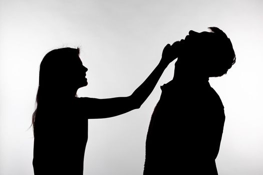 Aggression and abuse concept - man and woman expressing domestic violence in studio silhouette isolated on white background.