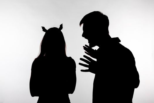 Couple man screaming at woman shouting dispute in studio silhouette isolated on white background. Woman with bat ears, halloween