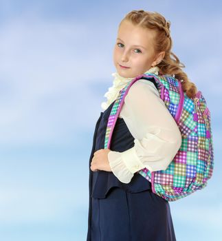 Beautiful girl schoolgirl with a satchel on his shoulders.
