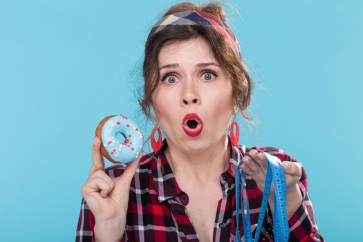 Diet, weight loss and junk food - Young woman choosing between doughnut and measuring type.